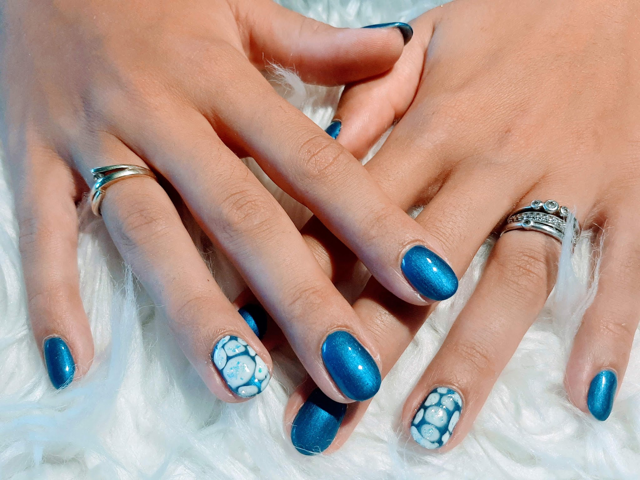 Metallic blauwe nagels met een bubbel nail art op twee nagels